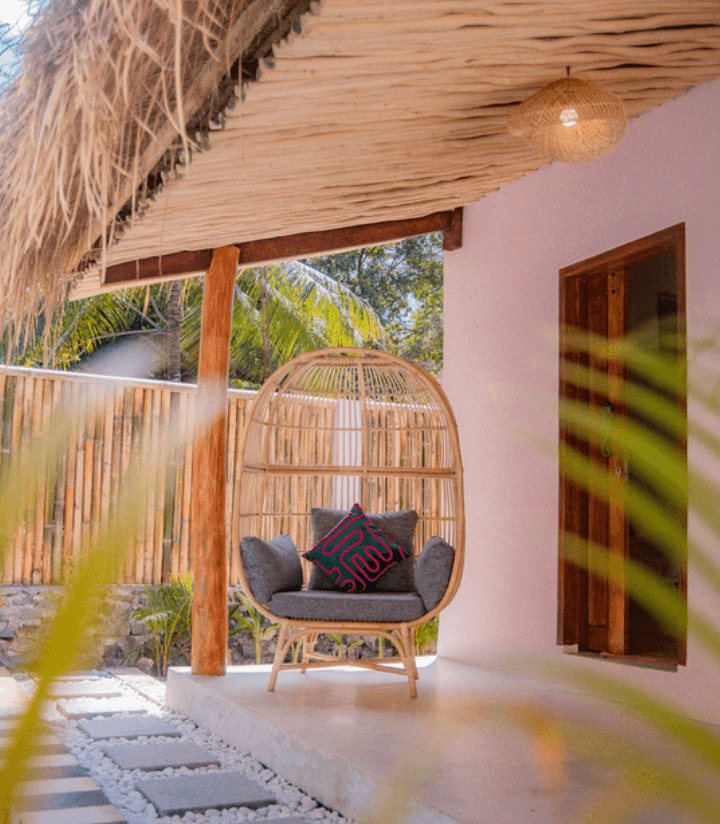 Terraza con techo de paja y sillón colgante